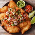 Fried tacos with toppings on a rustic plate
