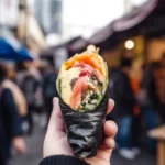 Hand holding a sushi burrito street food